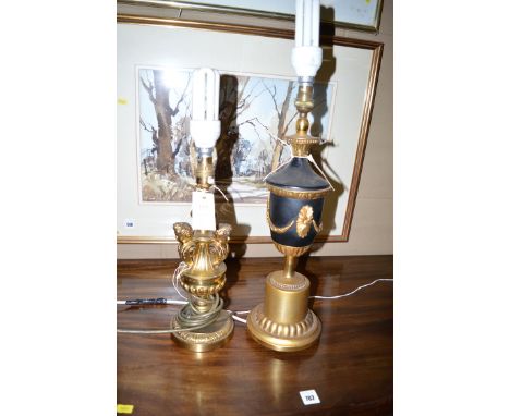 A modern cast brass lamp decorated three male busts; and an urn-shaped table lamp.