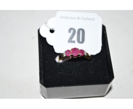 A ruby and diamond ring, the three oval facet cut rubies flanked by two diamonds either side, on 9ct. yellow gold shank, ring