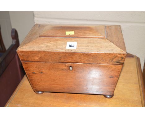 A rosewood sarcophagus-shaped tea caddy, c.1840, the shaped top opening to reveal an interior with two cupboards, raised on t