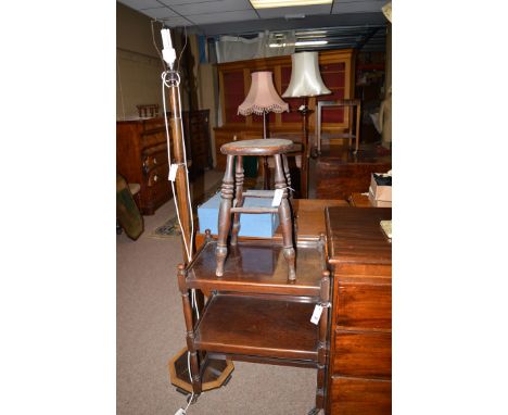 An oak two-tier trolley; an elm seat stool, raised on turned legs with stretchers; and an Art Deco stained wood standard lamp