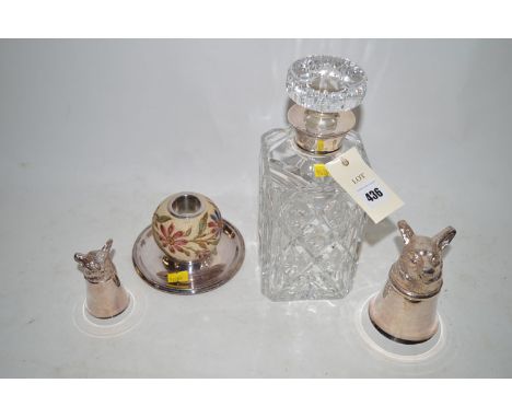 A cut glass whisky decanter with silver collar; two silver plated fox head stirrup cups; and an inkstand on silver plated bas