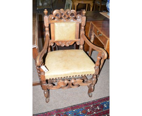 A 19th Century carved and stained wood hall/elbow chair, with ornate carved and pierced cresting rail, the seat and back upho