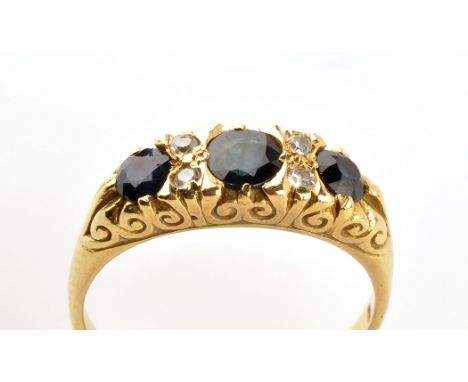 A sapphire and diamond ring, the three graduated circular facet cut sapphires separated by two pairs of eight-cut diamonds, i