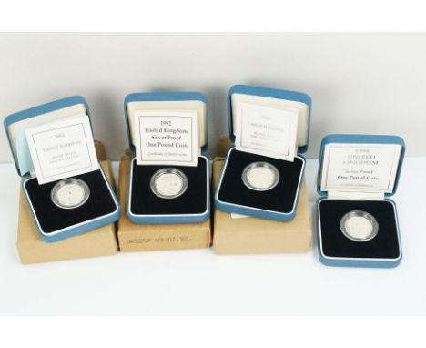 A collection of four Royal Mint Queen Elizabeth II £1 silver proof coins to include 1999, 2002, 2003 and 1992 examples, all e