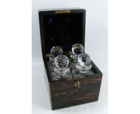 A 19th century coromandel decanter box, of square form with brass edges, the interior fitted with four square cut glass decan