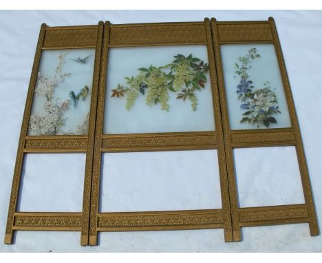 An Edwardian three panel folding screen, having three painted opaque glass panels decorated with flowers and birds, with fabr