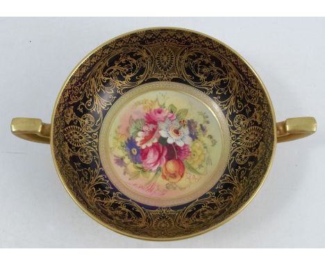A Royal Worcester two handled bowl, the interior decorated with a floral spray by E Phillips, to a blue and gilt border, the 