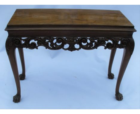 A 19th century mahogany and walnut console table, of rectangular form, the carved frieze decorated with scrolls, leaves and f