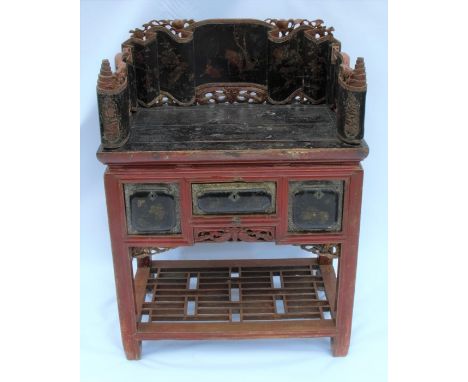 An Eastern painted side table, the top having three sides carved and decorated with Oriental scenes, fitted with three drawer