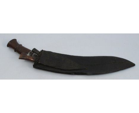 A Kukri style knife, with wooden handle, having a leather scabbard with two smaller knives