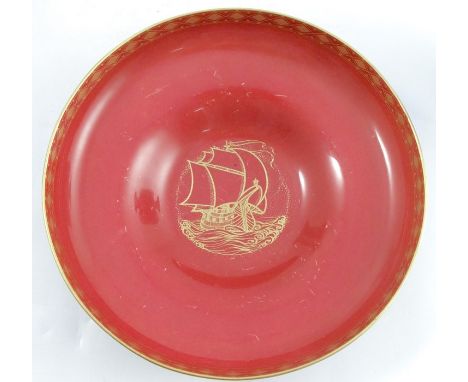 A Royal Worcester shallow pedestal bowl, the red interior decorated with a gilt ship at sea, the black exterior with gilt dia