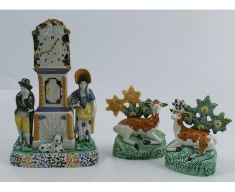 A 19th century Pratt ware Staffordshire pearlware money box, formed as a long case clock flanked by figures of a man and a wo