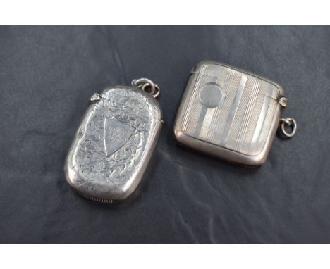 An Edwardian silver vesta case, having floral engraving and shield cartouche engraved 'WRE', along with a George V silver ves
