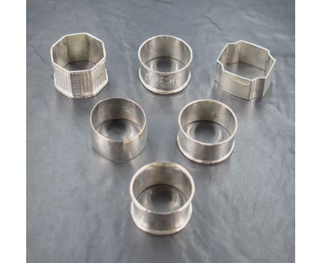 A group of six silver napkin rings, including engine turned decoration, some having monograms, others with vacant cartouches,