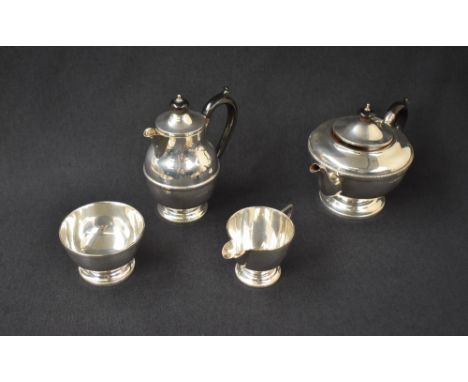 A George V silver four-piece tea set comprising a tea pot, hot water pot, sugar and cream, all of circular form, the rims wit