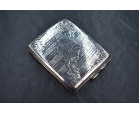 A late Edwardian silver cigarette case of hinged rectangular form, having engine turned decoration with trailing ribbon and s