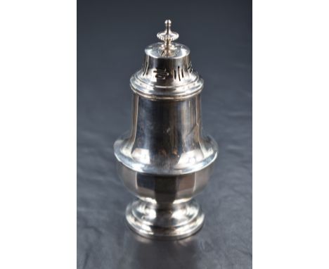 A George V silver sugar caster, having a pierced, finial topped cover over the fluted baluster body, raised on a step moulded