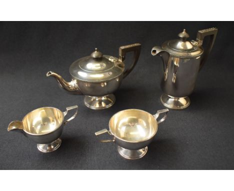 A George VI silver four-piece tea set comprising a tea pot, coffee pot, sugar and cream, all of circular form, the rims with 