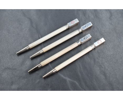 A cased set of four silver bridge mechanical pencils, having engine turned decoration and each having a playing card symbol t