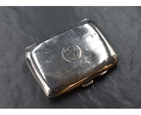An early George V silver cigarette case of hinged rectangular form, having engine turned decoration with a central circular c