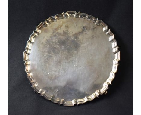 A large Elizabeth II silver salver, having Chippendale inspired rim, raised on four claw feet, marks for Birmingham 1964, mak