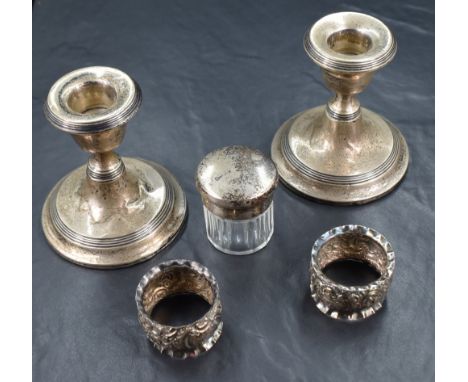 A pair of George V silver weighted candlesticks, of stout form with step line detail having round sconces raised on knopped s