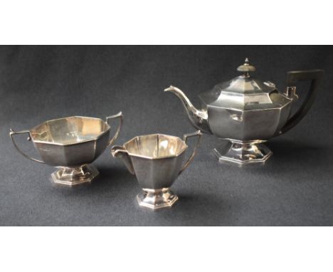 A George VI silver three piece tea set, comprising a tea pot, cream and sugar, having tapered geometric octagonal bodies, wit