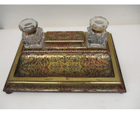 A Victorian Boulle desk stand surmounted a sarcophagus box with a hinged lid, flanked by a pair of clear glass, lidded inkwel