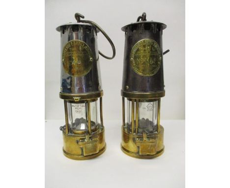 Two Protector Lamp & Lighting Co polished steel and brass miners safety lamps, one Type 6, stamped No 28, the other Type SL, 