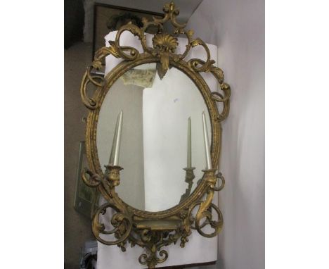 A Victorian gilt gesso girondale having an oval mirror set in a moulded frame with scroll, foliage and shell ornament, twin s