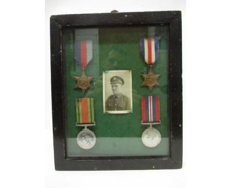 A group of four WWII medals, a Defence, 1939-1945, a 1939-45 Star and a France and German Star and a monochrome portrait phot