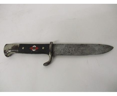 A WWII German Hitler Youth knife, the textured handle inset with a red and white diamond motif and Swastika, the blade stampe