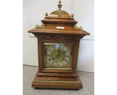 A late 19th century walnut mantle clock, the brass dial having a matted centre, silvered chapter ring, Roman numerals and fou
