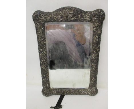 A Victorian silver coloured metal dressing table mirror with floral embossed decoration, on a brown leather clad easel back, 