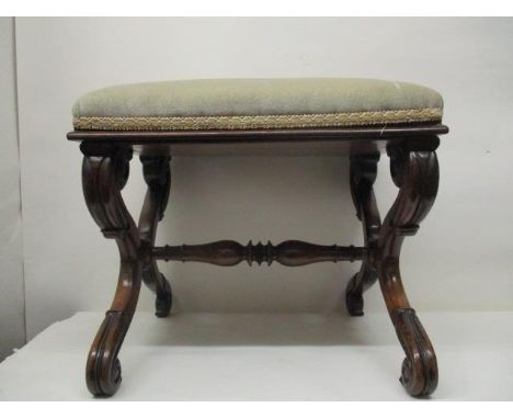 A William IV rosewood stool having an upholstered top, on carved, scrolled double S shaped ends, united by a turned stretcher