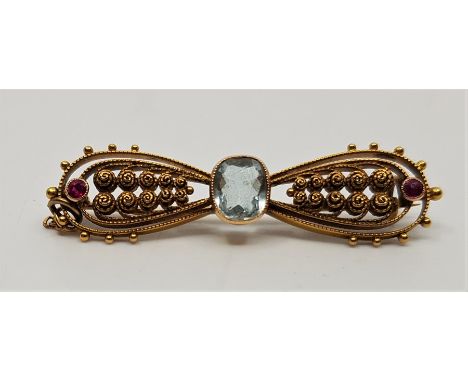 A late 19th century precious yellow metal, aquamarine and ruby 'bow' brooch,&nbsp;set mixed cut aquamarine to centre, the ope