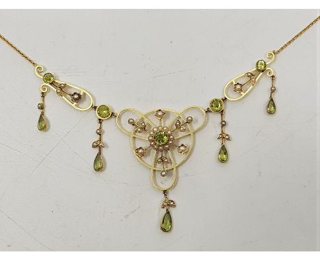 A precious yellow metal peridot and seed pearl necklace, in the belle epoque style, the open work hinged mounts set round cut