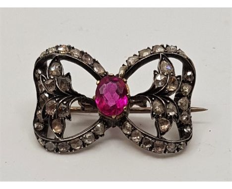 A Victorian precious metal and diamond "bow" brooch,&nbsp;later set oval mixed cut synthetic ruby to centre, with numerous gr