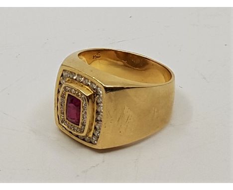 An 18ct. gold, ruby and diamond gentleman's ring, the raised cushion shape centre set mixed cut ruby surrounded by round cut 