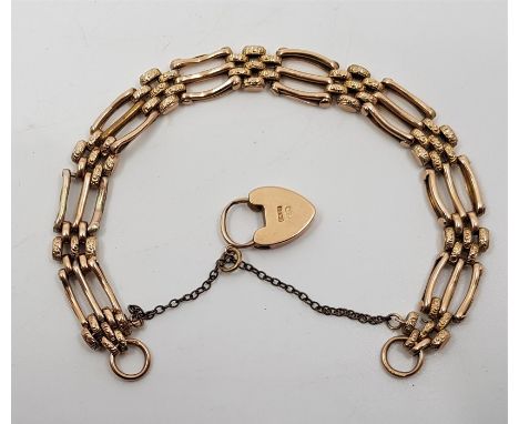 A 9ct. gold gate bracelet, with 9ct. gold heart padlock clasp. (10.9g)Condition: Solder repairs (as found).