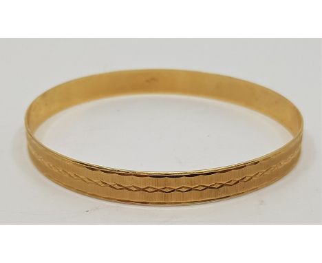 A Continental 14ct. gold bangle, with engraved and engine turned decoration, external diameter 70mm. (14.8g)