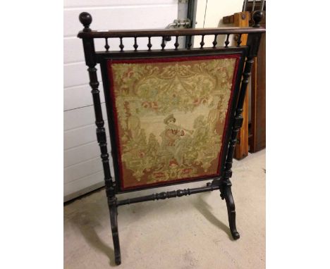 A large Victorian tapestry fire screen with turned wood supports and stretcher and galleried top.