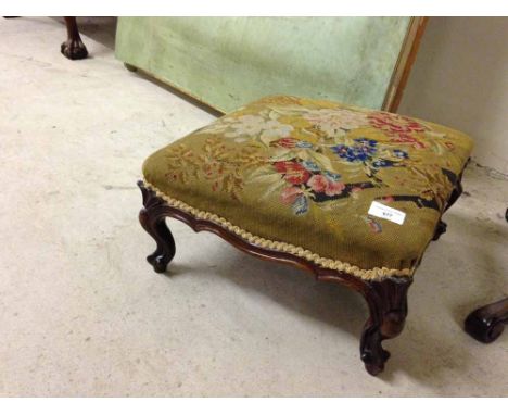 A Victorian square footstool with carved legs and tapestry upholstery