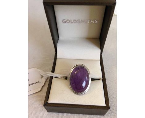 A ladies silver ring set with a large oval purple cabouchon, size R