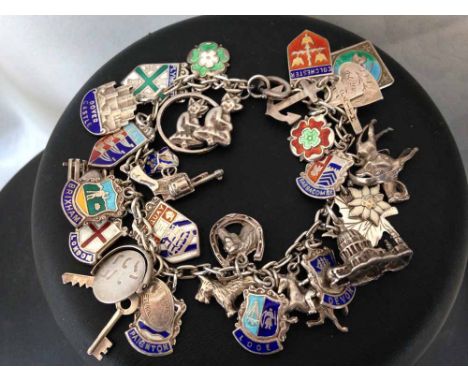 Vintage silver charm bracelet with 11 enamelled place shields and 20 other silver charms including horses. Weight approx 51g.