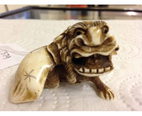 A signed netsuke of a monkey in a lion costume.
