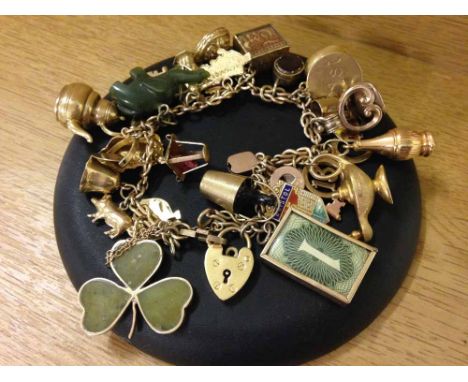 A 9ct gold charm bracelet set with 30 charms (majority 9ct gold) to include seal with Pegasus design and Jade elephant. Appro