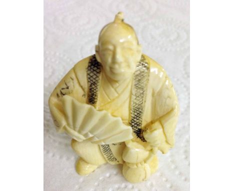 A signed netsuke of a man with a fan & gourd.