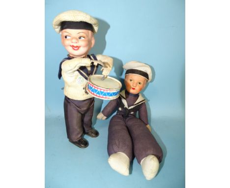 A West German clockwork sailor doll playing a drum, with composition head, card body and tinplate hands, feet and drum, 24cm 