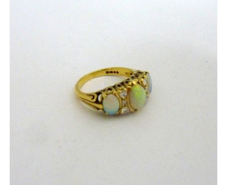 AN 18CT GOLD OPAL AND DIAMOND RING, with three large oval opals to a trio of brilliant cut diamonds either side of the centra